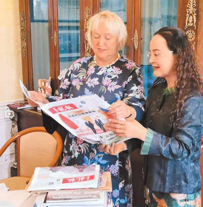李双杰（右）向俄罗斯友人展示《龙报》。